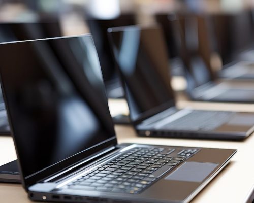 empty-laptops-arranged-neatly-long-table-modern-tech-workspace-daylight-hours_698249-18692