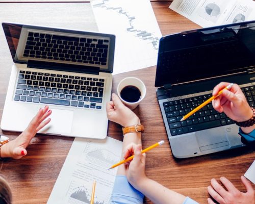 people-sitting-desk-with-laptops-working_23-2147650929